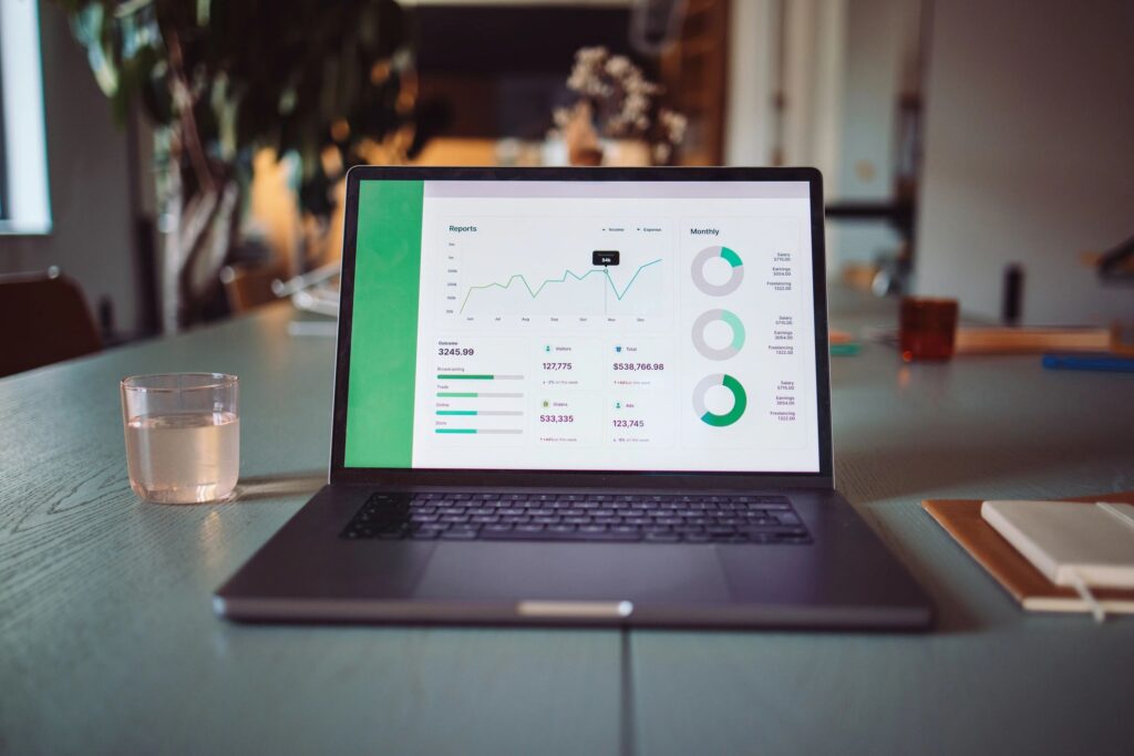 Open Laptop Displaying Data Analytics Report on Wooden Table in Office